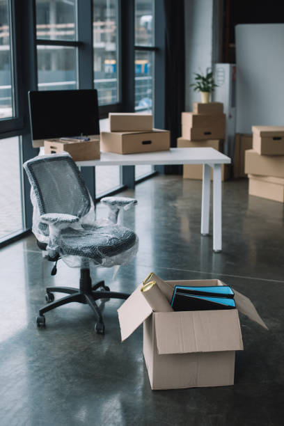 istock wrapped chair and cardboard boxes in office during relocation 1008848016