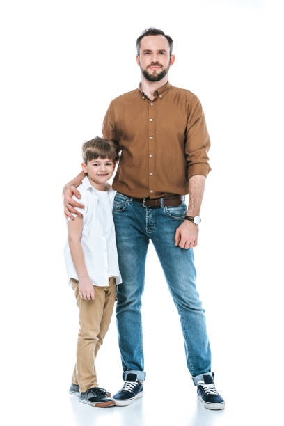 full length view of happy father and son standing together and smiling at camera isolated on white - boyhood imagens e fotografias de stock