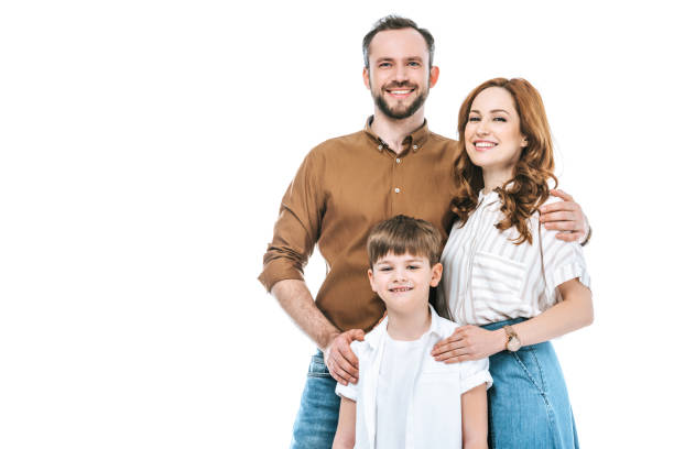 красивая счастливая семья с одним ребенком, стоящим вместе и улыбаясь в камеру изолированы на белом - boyhood стоковые фото и изображения
