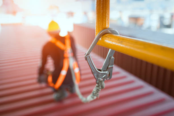 Working at height equipment,Construction worker wearing safety harness belt during working on roof structure of building on construction site.