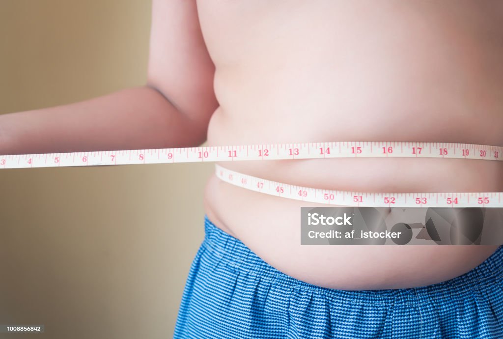 Fat boy with overweight checking Fat boy with overweight checking out his weight isolated on white background Overweight Stock Photo