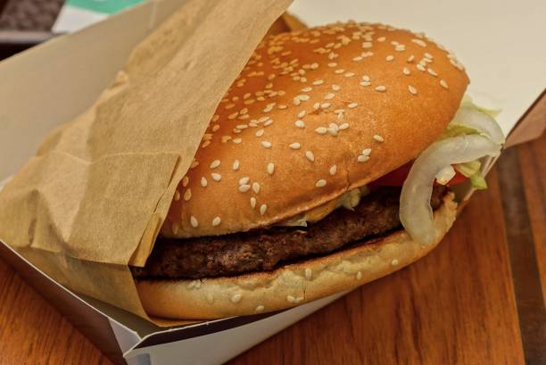 istock brown cheeseburger in paper packing on the table 1008856972