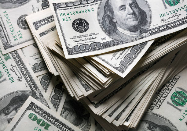 stack of one hundred dollars notes stack of one hundred dollars notes on dollars background us currency stock pictures, royalty-free photos & images