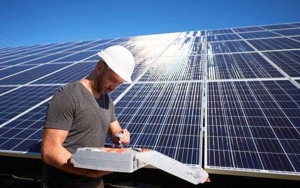 istock Concentrated architect keeping equipment standing near solar panels. 1008870086