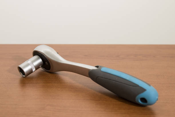 istock Tools, blue ratchet wrench and accessories on a wood table composition 1008873014