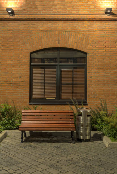 istock Evening in the old quarter. Office building in loft style. Brick building with large Windows, bench and an urn. 1008876894