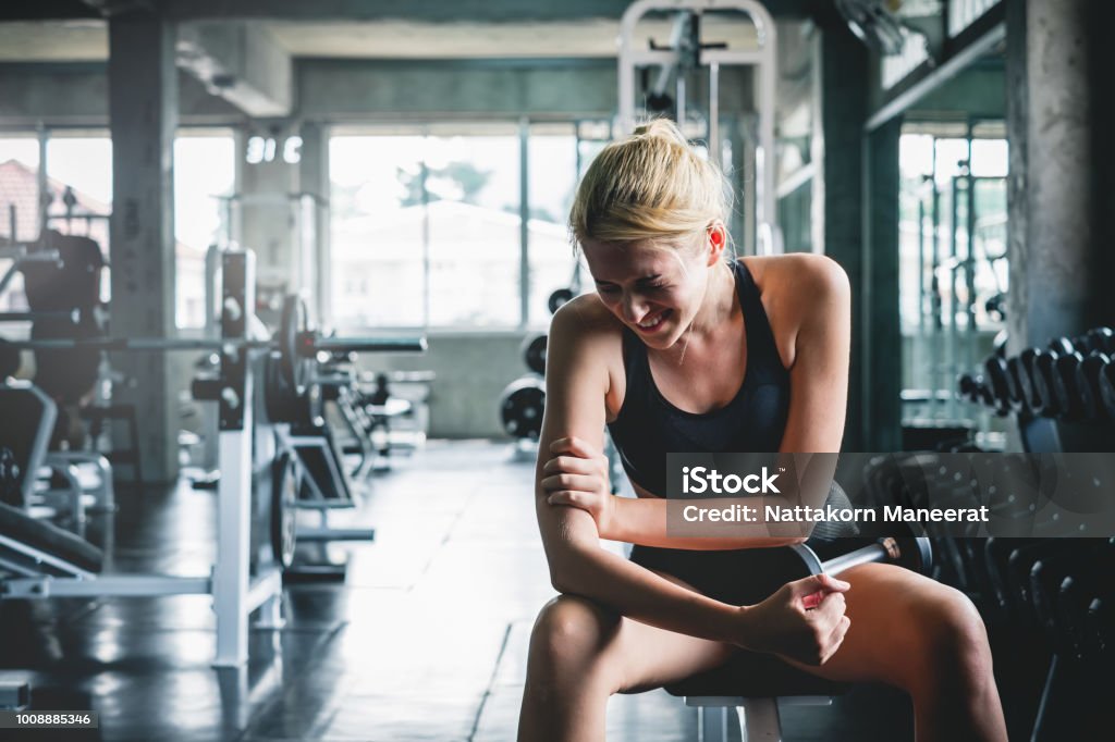 Woman have accident injury and hurt at arms while workout and weight training at gym, muscle pain concept Pain Stock Photo