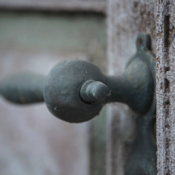 old rusty front door handle close-up on a wooden door with cracked paint. - rust metal fotos imagens e fotografias de stock