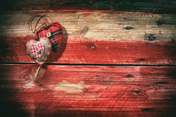 istock Decorative hearts on red wooden background 1008885830