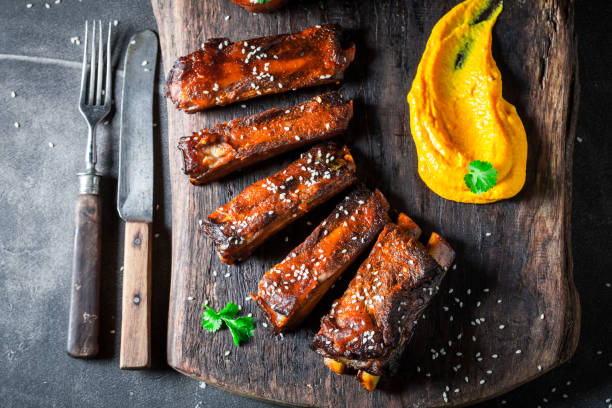 istock Delicious roasted ribs with vegetables and potato on dark table 1008888060