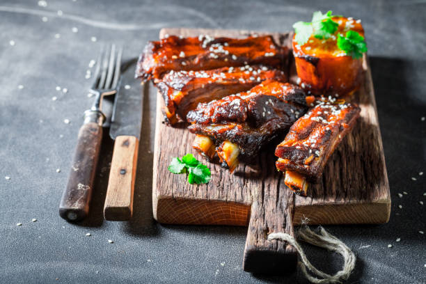 istock Tasty roasted ribs with vegetables and potatoon dark table 1008888110