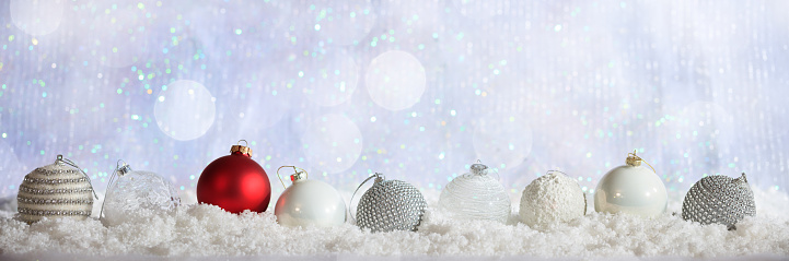 White and red Christmas balls on abstract cold winter background with snow