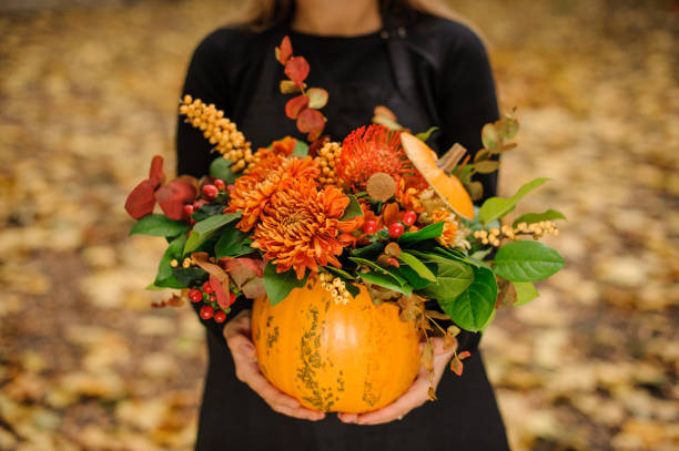 花とカボチャを持って黒いドレスの女 - single flower flower autumn pumpkin ストックフォトと画像