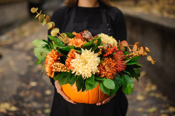 女性の手で花の美しい花束とオレンジ色のカボチャ - single flower flower autumn pumpkin ストックフォトと画像