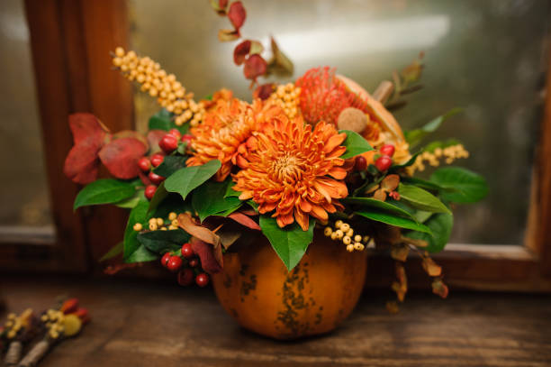 Pumpkin with a beautiful bouquet of autumn flowers inside stock photo