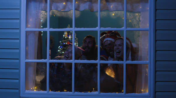 istock Excited friends looking out in window during Christmas 1008922198