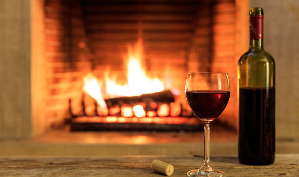 istock A glass and a bottle, fireplace background 1008922360