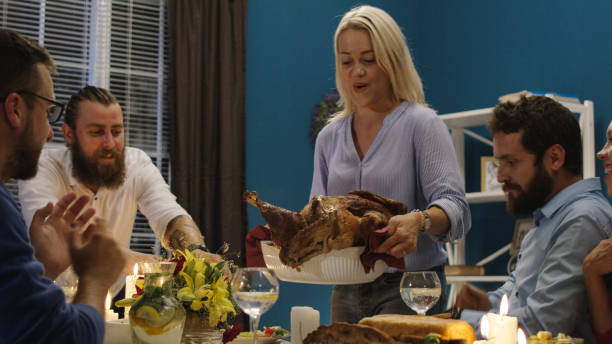 Woman serving holiday turkey on dinner with friends