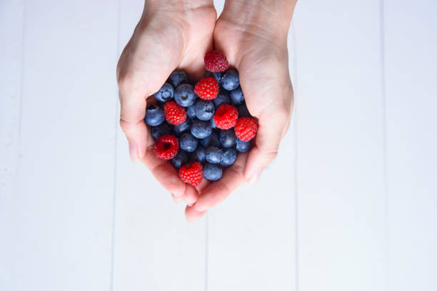 istock Fresh blueberries and raspberries in women's hands 1008923212