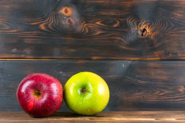 ripe juicy red and green apples on rustic wooden table