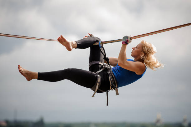 istock Professional female equilibrist hanging on the slackline upside down 1008950158