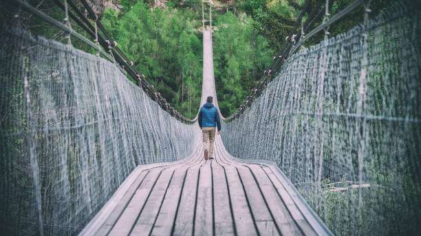 Switzerland, May 2017: Man walking down in Goms Hanging Bridge in Switzerland