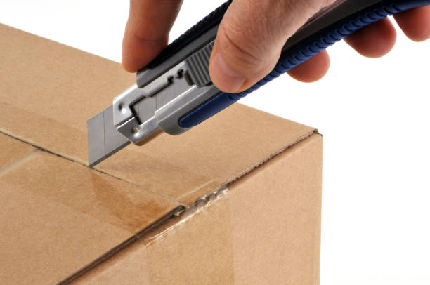 open a box with a cutter - putty knife imagens e fotografias de stock