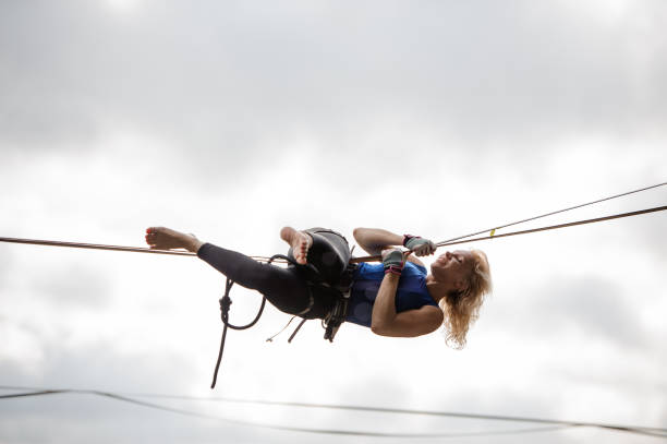 istock Girl hanging on the slackline upside down 1008957714