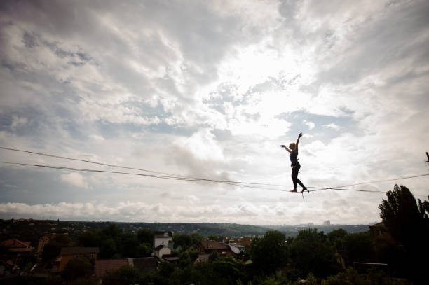 istock Young woman making steps on the slackline rope 1008957732