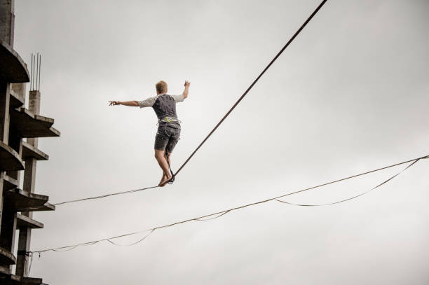 istock Young active man walking on the slackline rope 1008957992