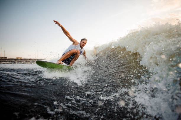 istock Young attractive active man riding on the wakeboard on the lake 1008961830