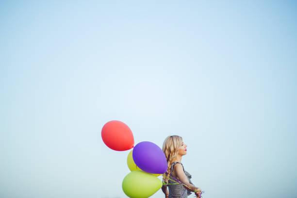 istock Blond woman with colorful balloons outside. 1008965932