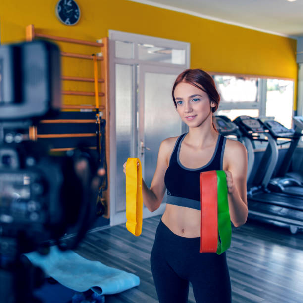 istock Women doing an exercise vlog - fitness workout with stretch bands. 1008985144