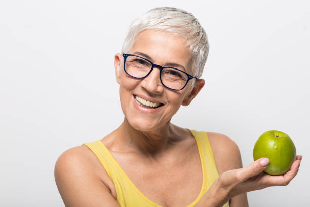 istock Mature woman holding an apple 1008987996