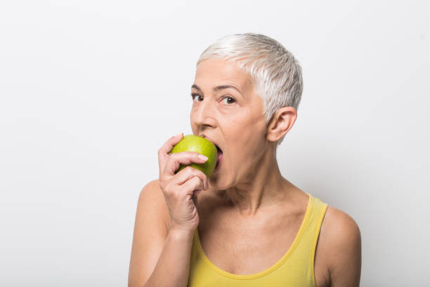 istock Senior woman biting an apple 1008988016