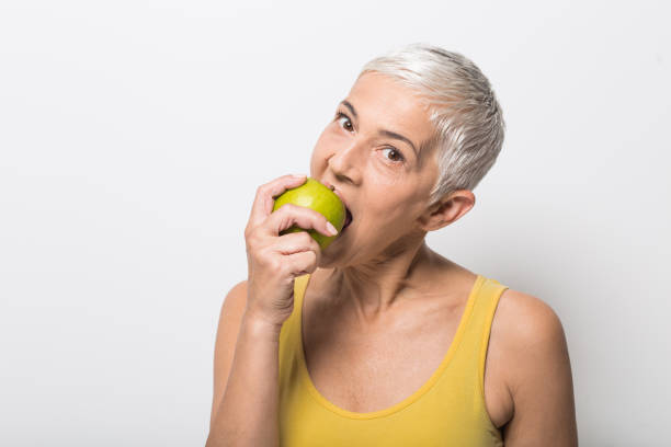 istock Mature woman eating an apple 1008988032