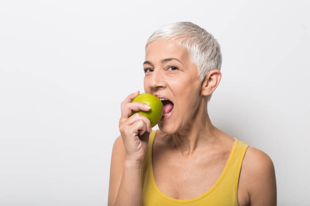 istock Happy mature woman biting an apple 1008988040