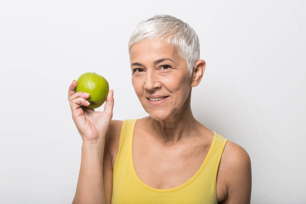 istock Smiling older woman holding an apple 1008988046