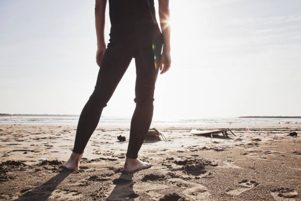 istock Male surfer standing on the beach 1008988064