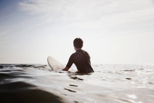 männliche surfer wellen warten - surfing surf wave men stock-fotos und bilder