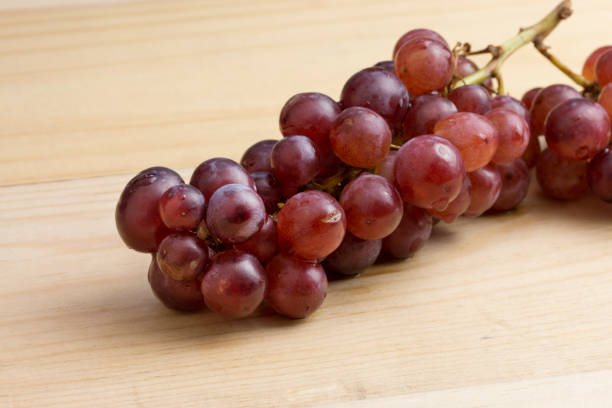 istock group of fresh red grape on wood table 1008994164
