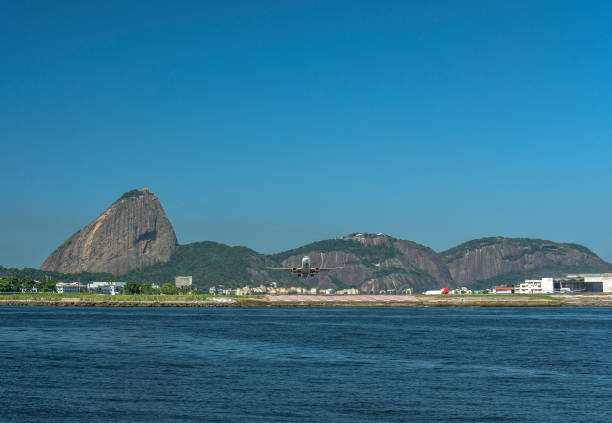 Bay of Guanabara view from the sea, with Santos Dumont Airport and hills of Urca and Sugar Loaf in the background Photo taken from Santos Dumont Airport in Guanabara Bay, view of the sea to the mainland, with the hills of Urca and Sugar Loaf, with a plane taking off corcovado stock pictures, royalty-free photos & images