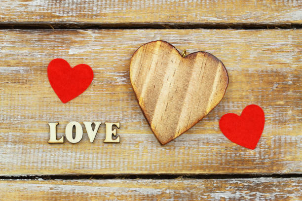 istock Word love written with wooden letters and hearts on rustic surface 1009017214