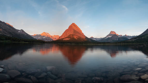 swiftcurrent lake with reflection of mountain sunrise - mount grinnel imagens e fotografias de stock