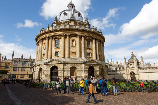 Radcliffe Camera - Oxford Oxford, UK: May 07, 2014: Street view of the Radcliffe Camera in Oxford, part of the Bodleian Library complex at Oxford University. Tourists walk along the street. bodleian library stock pictures, royalty-free photos & images