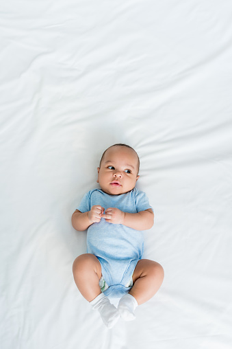 top view of adorable little child lying on bed