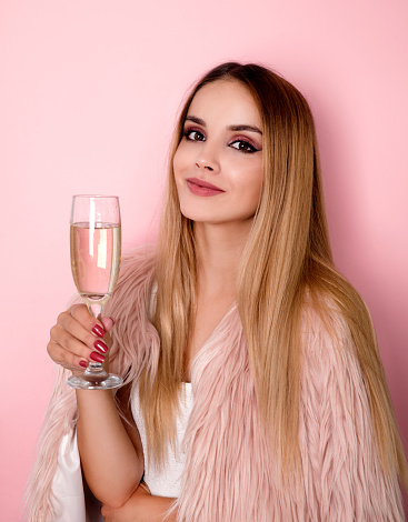 Young smiling woman holding glass with champagne