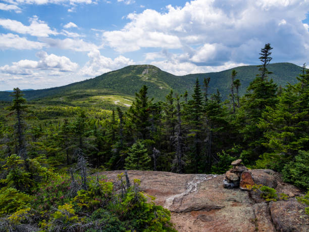 A view along the Appalachian trail in the Mahoosuc Range in Maine, a rock cairn marking the trail.