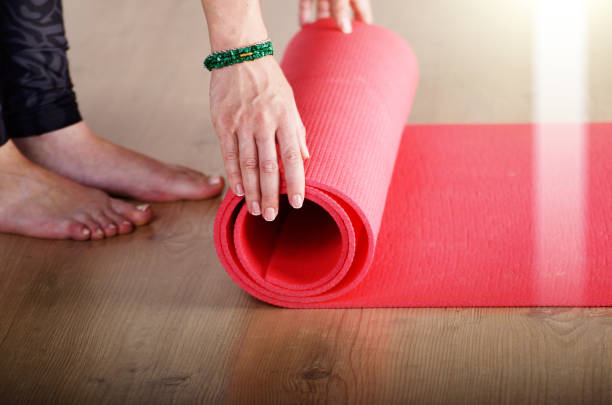 istock Female hands unrolling yoga mat before workout exercise. Healthy lifestyle concept 1009036494