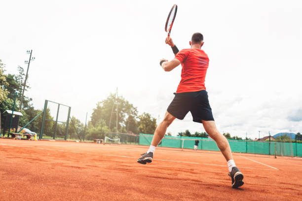 istock Young man is playing tennis on fresh sunny morning 1009042546